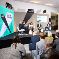 Blick auf ein Podium mit fünf sitzenden und diskutierenden Personen